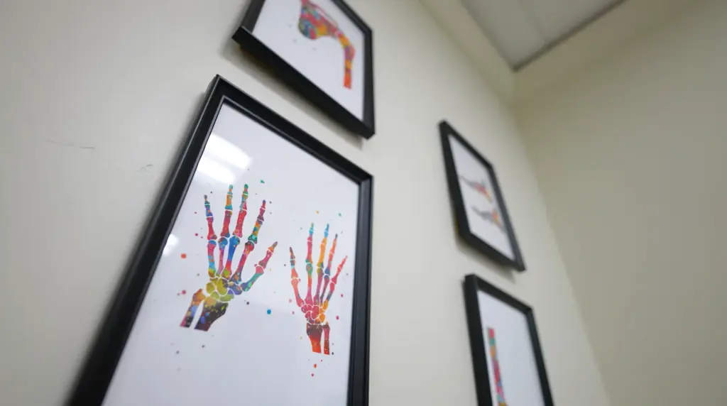 Artwork hanging on a wall depicting bones in hands.